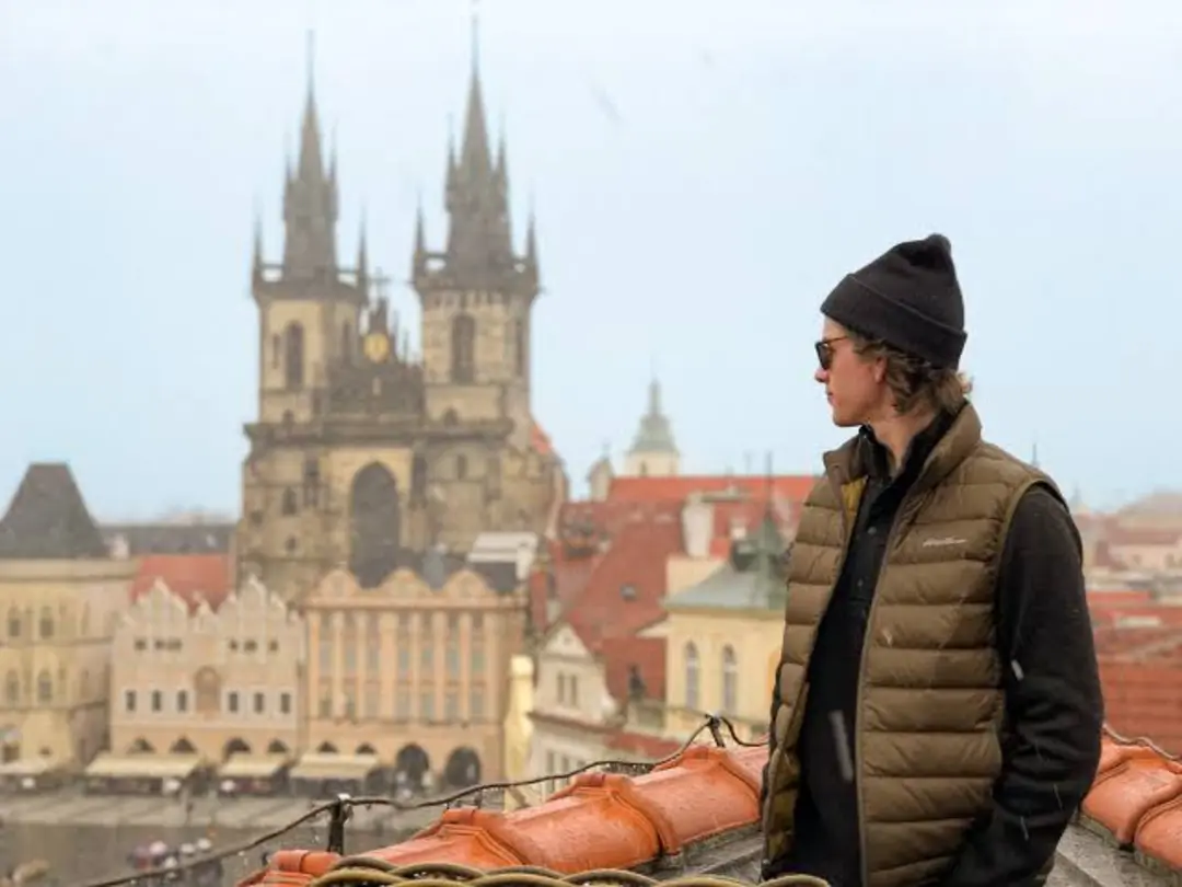 دانشجوی آمریکایی (American student) با نمای برج‌های تاریخی شهر پراگ (Prague)