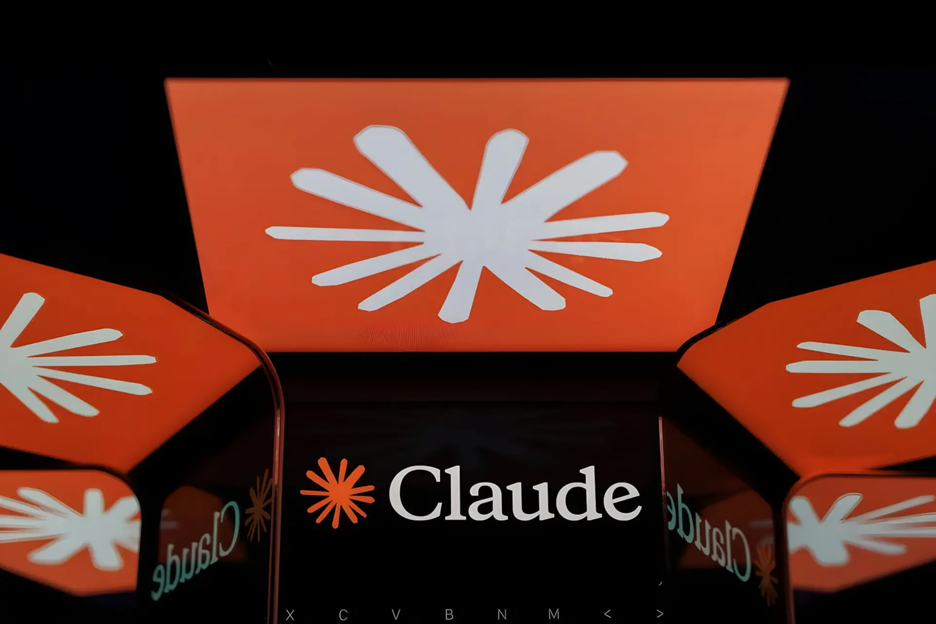 نمای نزدیک از لوگوی نارنجی رنگ هوش مصنوعی کلاد (Claude) روی صفحه نمایش