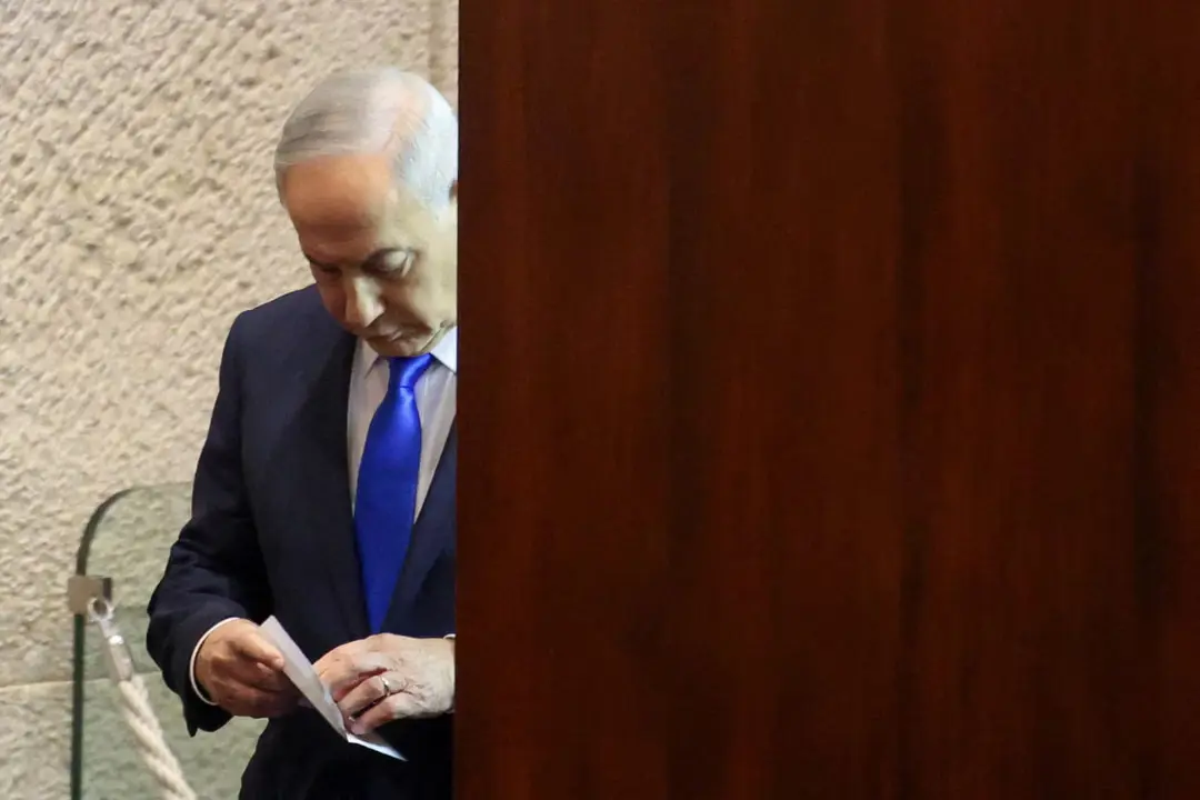 بنیامین نتانیاهو (Benjamin Netanyahu) در حال بررسی یک برگه کاغذ در فضای سیاسی اسرائیل