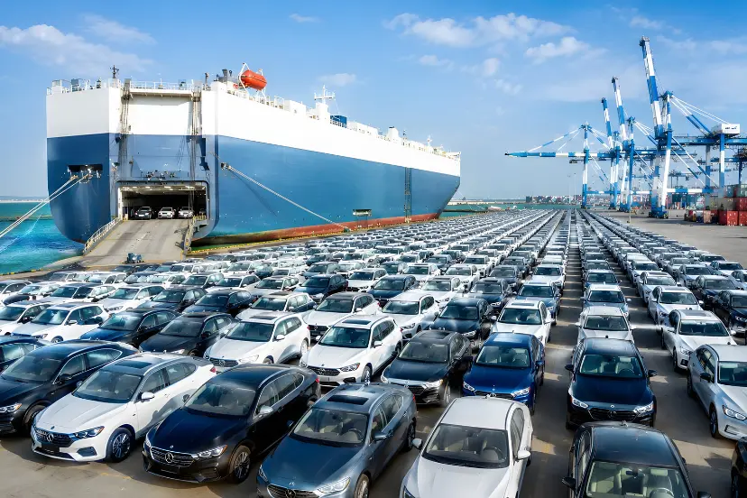 کشتی حمل خودرو (Car Carrier) در کنار پارکینگ بزرگ خودروهای جدید در بندر