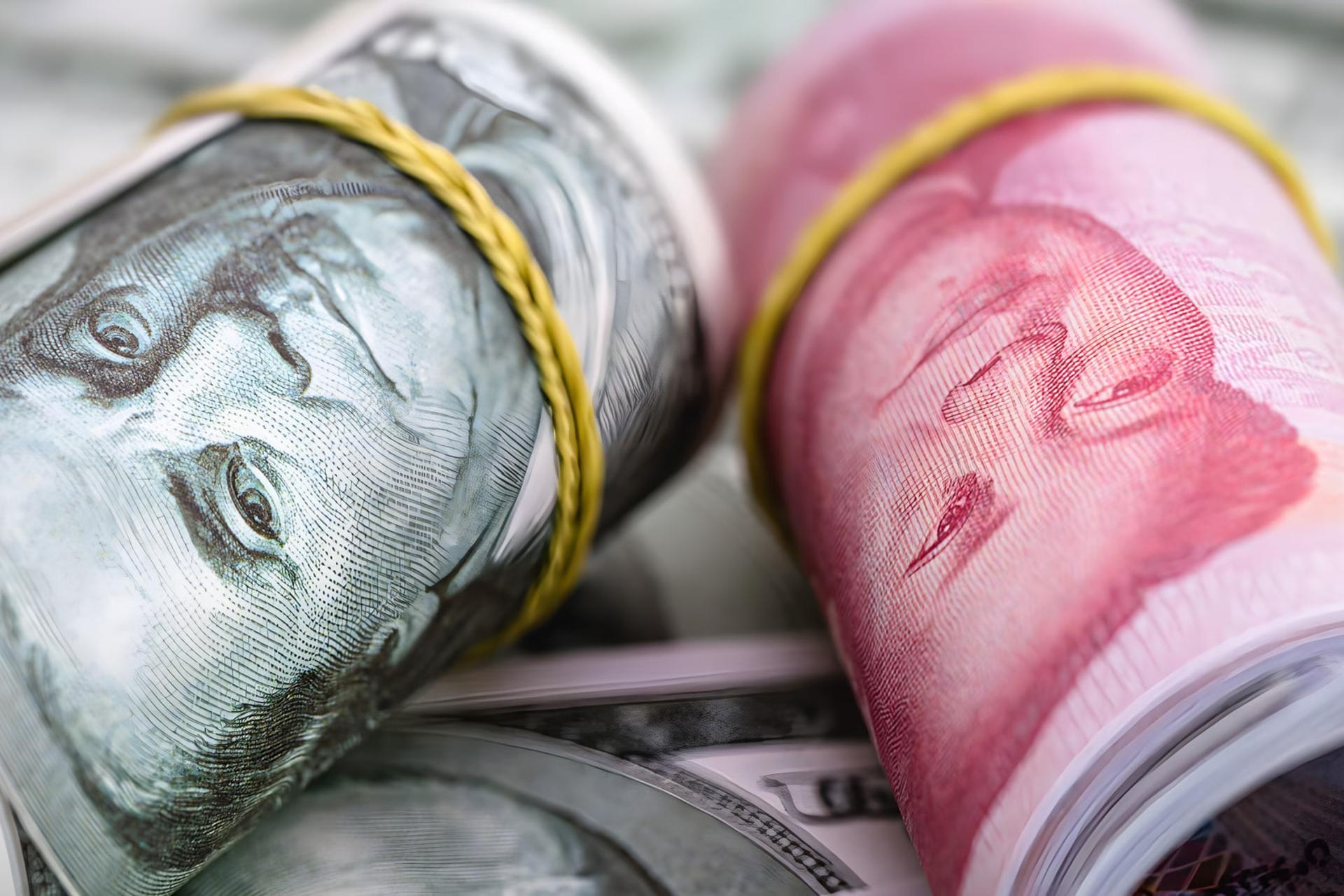 رول‌های اسکناس دلار آمریکا (US Dollar) و یوآن چین در کنار هم