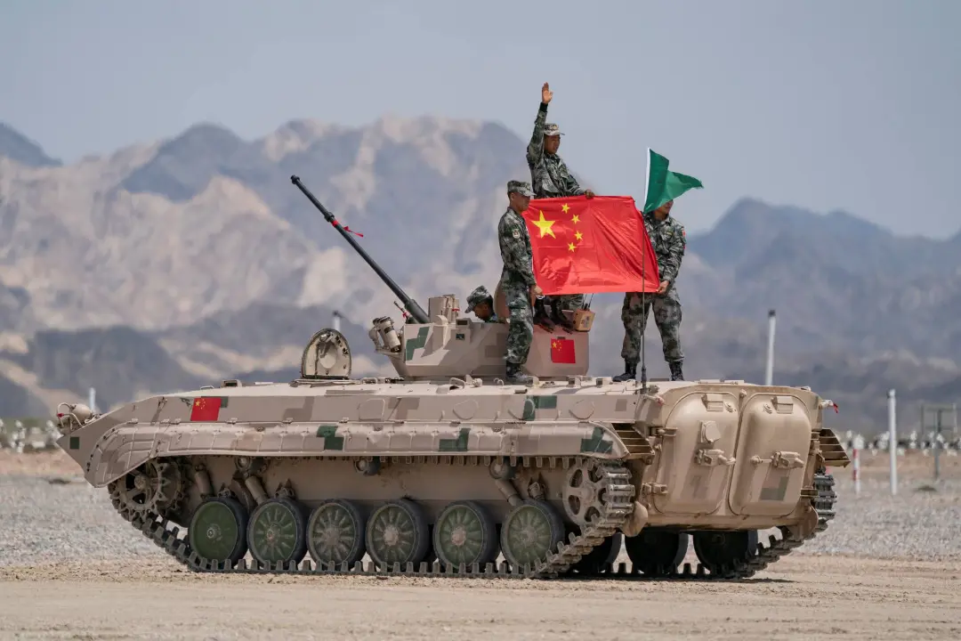 خودروی زرهی ارتش چین (People's Liberation Army) با پرچم سرخ در میدان