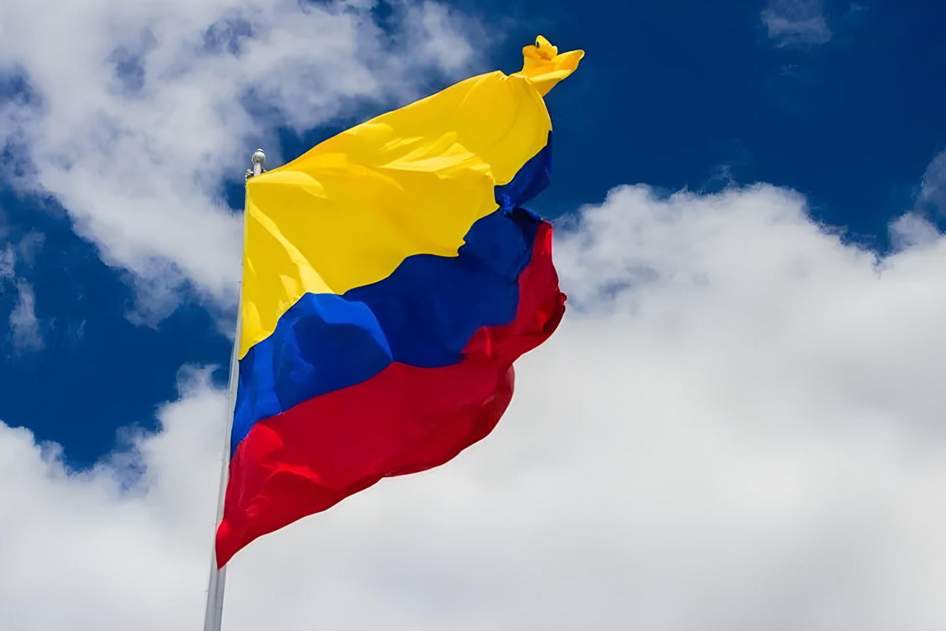 پرچم کلمبیا (Colombia) در مقابل آسمان آبی و ابرها
