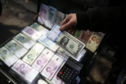 دستی که در حال برداشتن یا شمردن اسکناس‌های یک دلاری آمریکا از داخل یک صندوق پول است.