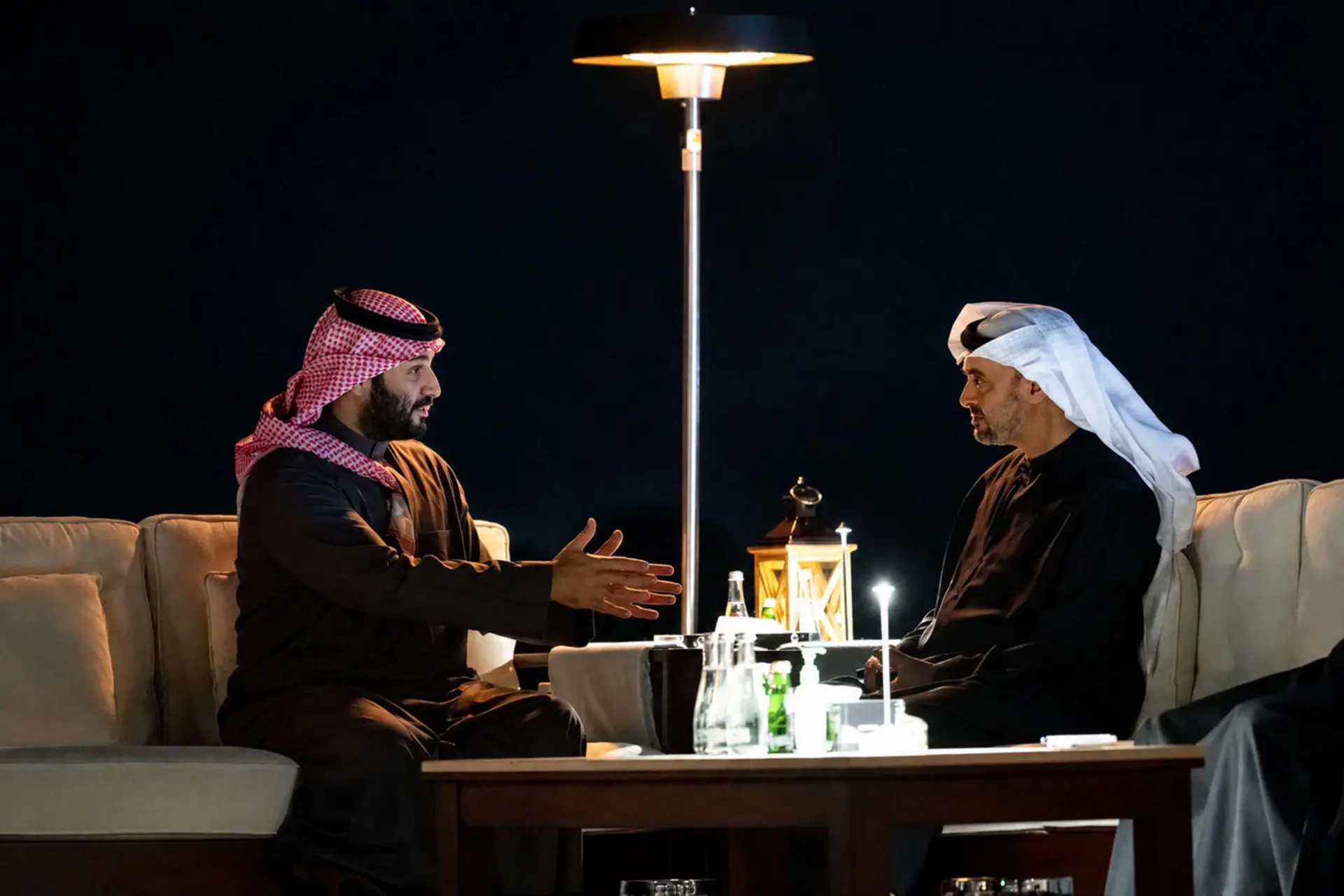 محمد بن زاید بن سلطان آل نهیان و محمد بن سلمان در حال گفتگو در فضای باز در شب هستند.