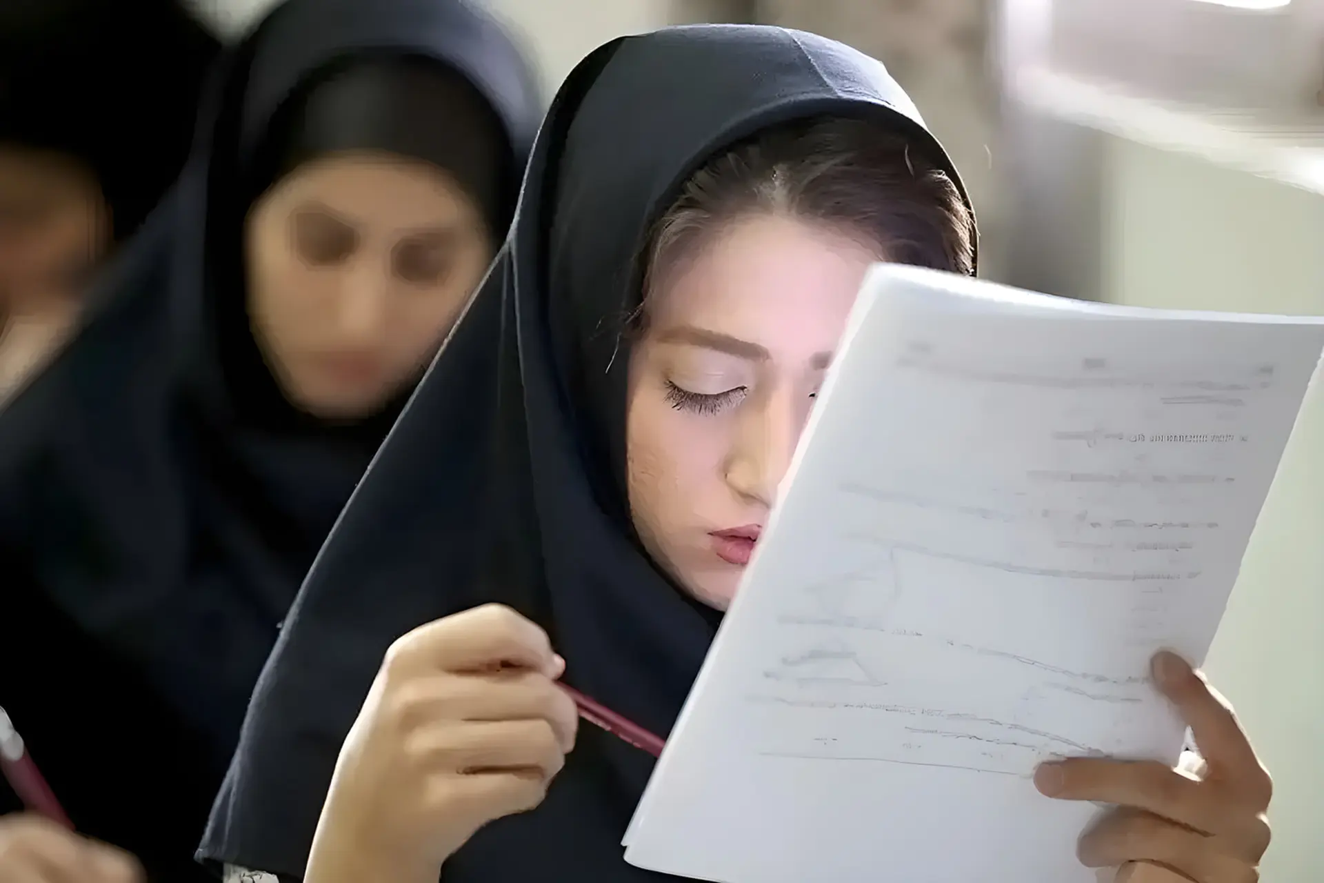 دانش‌آموز دوازدهم در حال بررسی برگه‌های امتحانات نهایی