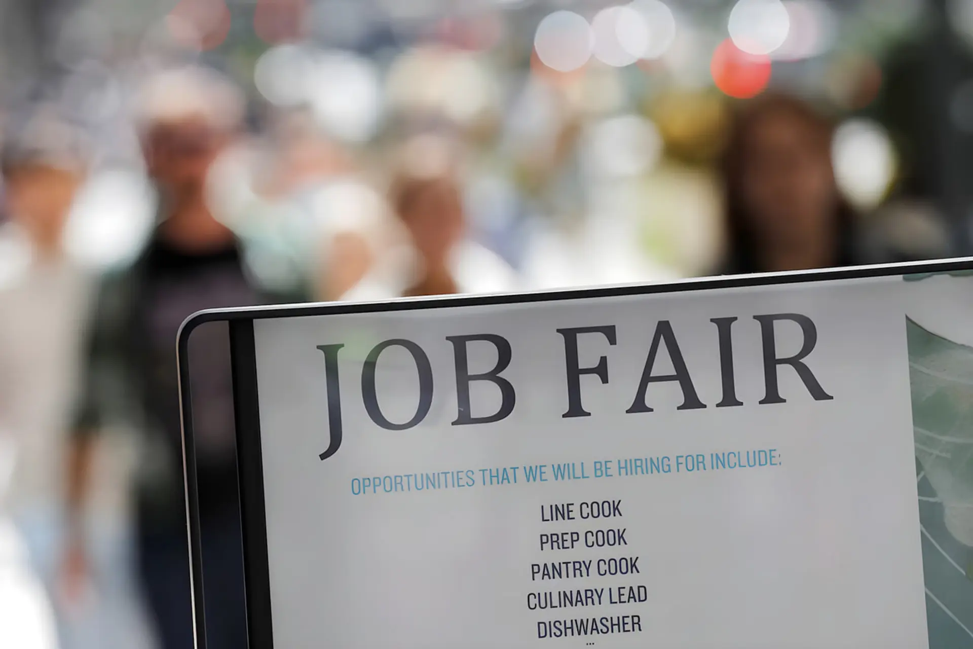 تابلوی سفید رنگ با نوشته JOB FAIR در فضای باز