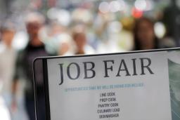 تابلوی سفید رنگ با نوشته JOB FAIR در فضای باز