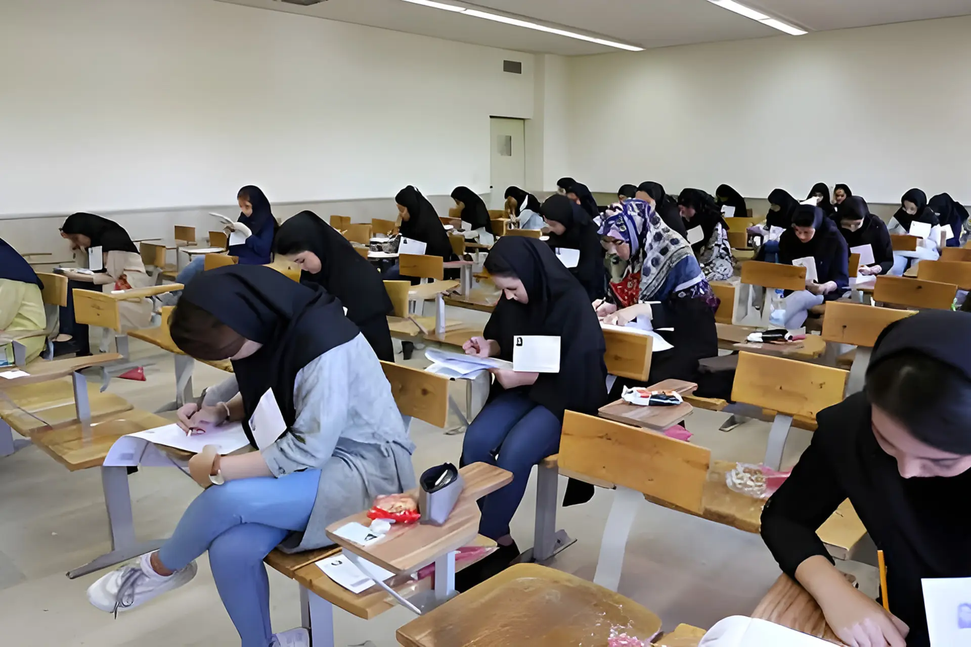داوطلبان کنکور در حال پاسخ‌دهی به سوالات در یک سالن امتحانی