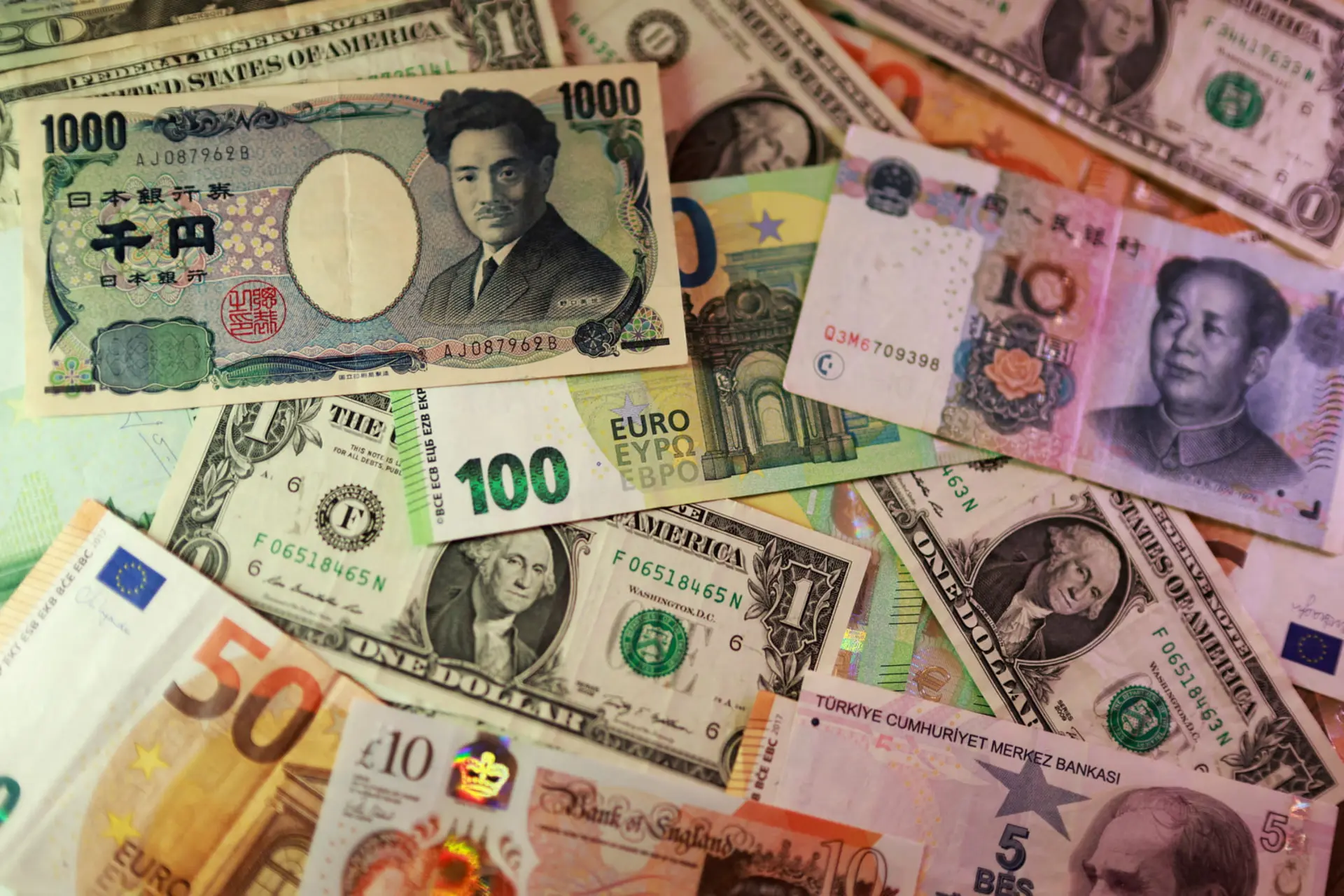 اسکناس‌های متنوع از جمله ین ژاپن (Japanese Yen) و یورو و دلار آمریکا روی هم قرار گرفته‌اند