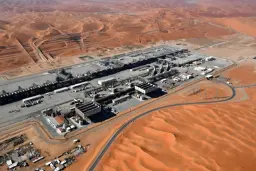مجموعه تاسیسات و تجهیزات صنعتی در میان تپه‌های شنی کویر