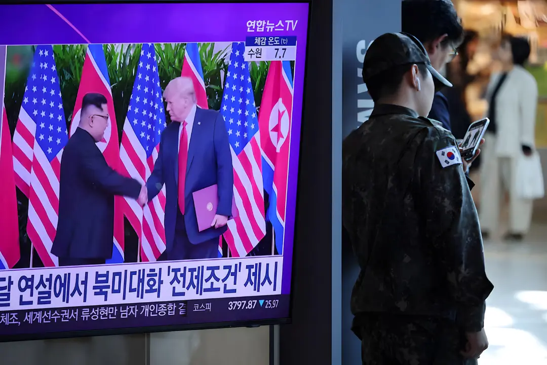 کیم جونگ اون (Kim Jong Un) و دونالد ترامپ (Donald Trump) در حال دست دادن در مقابل پرچم‌ها
