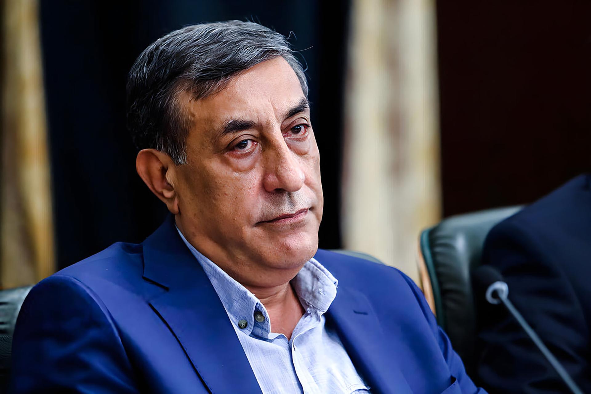 مردی با کت و شلوار آبی در یک جلسه رسمی