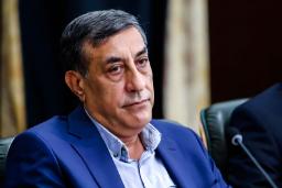 مردی با کت و شلوار آبی در یک جلسه رسمی