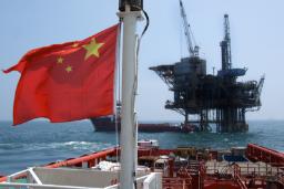 پرچم چین (China) در مقابل یک سکوی استخراج نفت در دریا