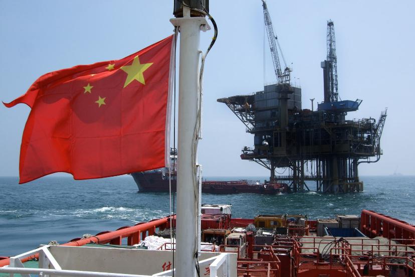 پرچم چین (China) در مقابل یک سکوی استخراج نفت در دریا