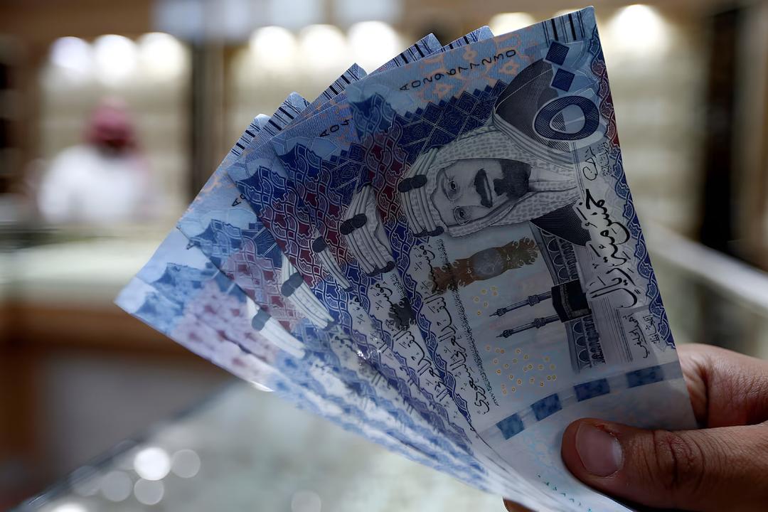اسکناس‌های ریال عربستان (Saudi Riyal) در دست یک فرد