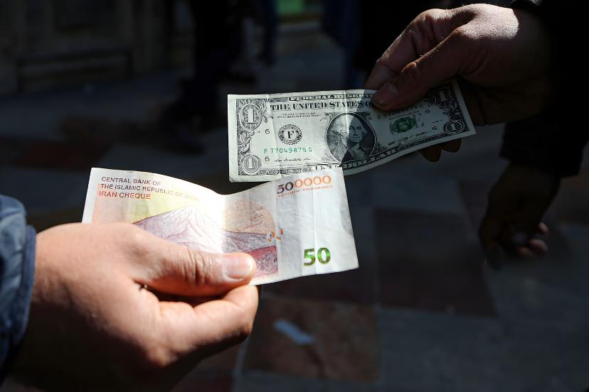 دلار آمریکا (US Dollar) و اسکناس ۵۰۰ هزار ریالی در دست دو نفر