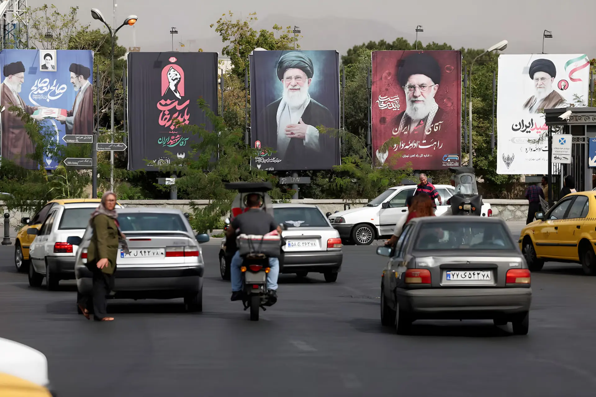 بیلبوردهای تبلیغاتی با تصاویر رهبر ایران (Ali Khamenei) در کنار ترافیک شهری