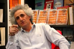 محسن نامجو (Mohsen Namjoo) در کنار کتاب‌های خود در کتابخانه