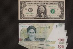 اسکناس یک دلاری آمریکا (US Dollar) و اسکناس‌های ده هزار ریالی ایران روی میز