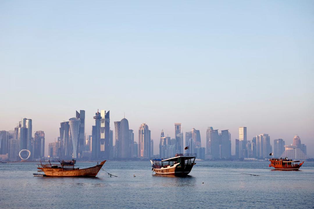 آسمان‌خط شهر دوحه (Doha) و قایق‌های سنتی در خلیج فارس