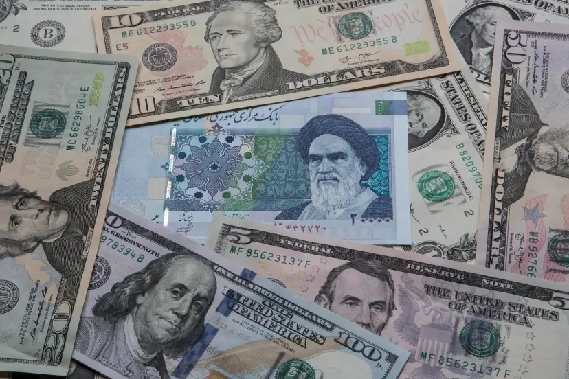 اسکناس‌های دلار آمریکا و پول ملی ایران (Rial) روی هم قرار گرفته‌اند