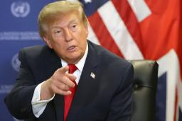 دونالد ترامپ (Donald Trump) در حال سخنرانی در یک نشست رسمی با پرچم آمریکا در پس‌زمینه