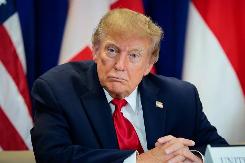 دونالد ترامپ (Donald Trump) با چهره‌ای جدی پشت میز نشسته‌ است