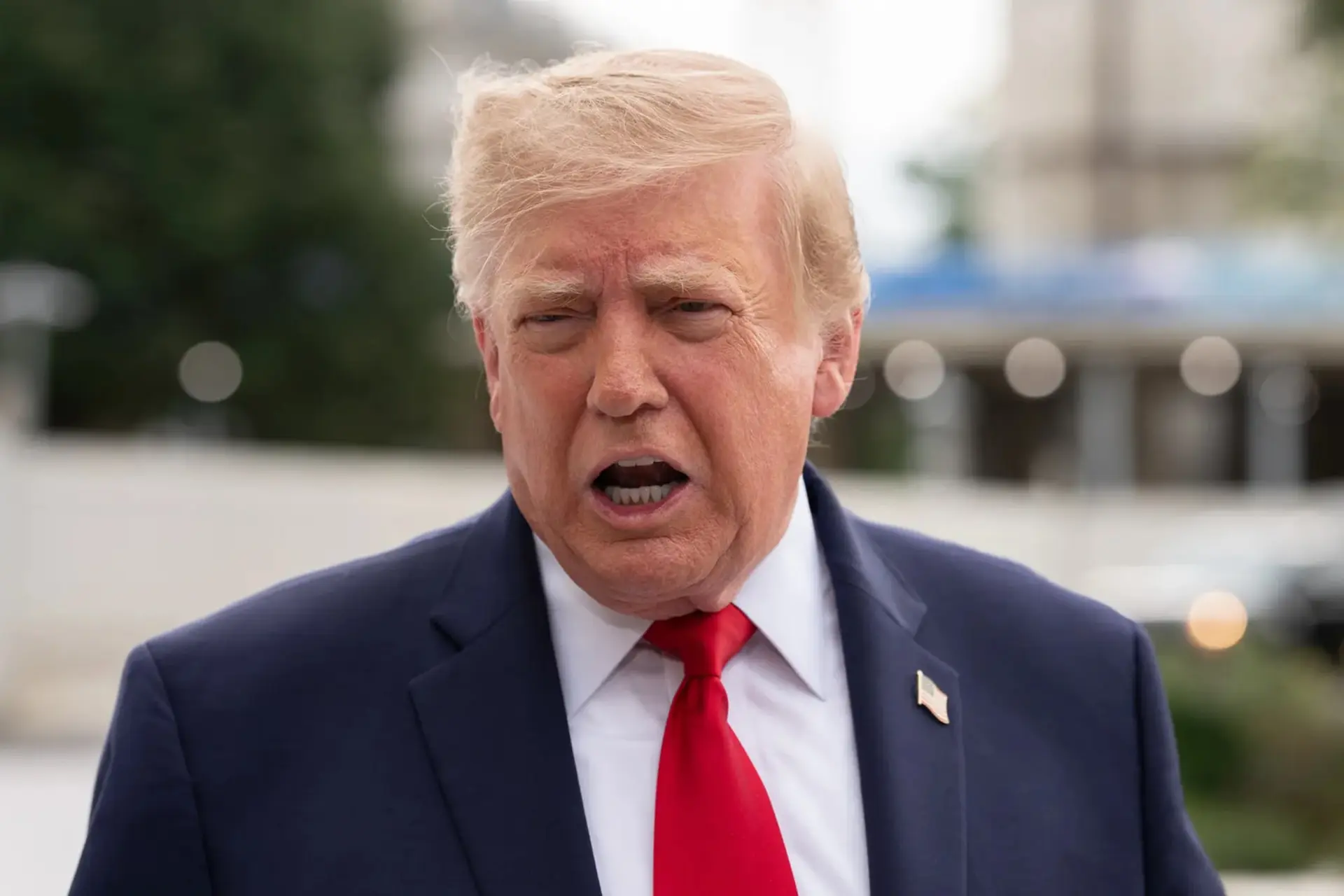 دونالد ترامپ (Donald Trump) با کت و کراوات قرمز در حال صحبت کردن