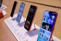 گوشی‌های هوشمند آیفون (iPhone) روی پایه نمایش در فروشگاه موبایل
