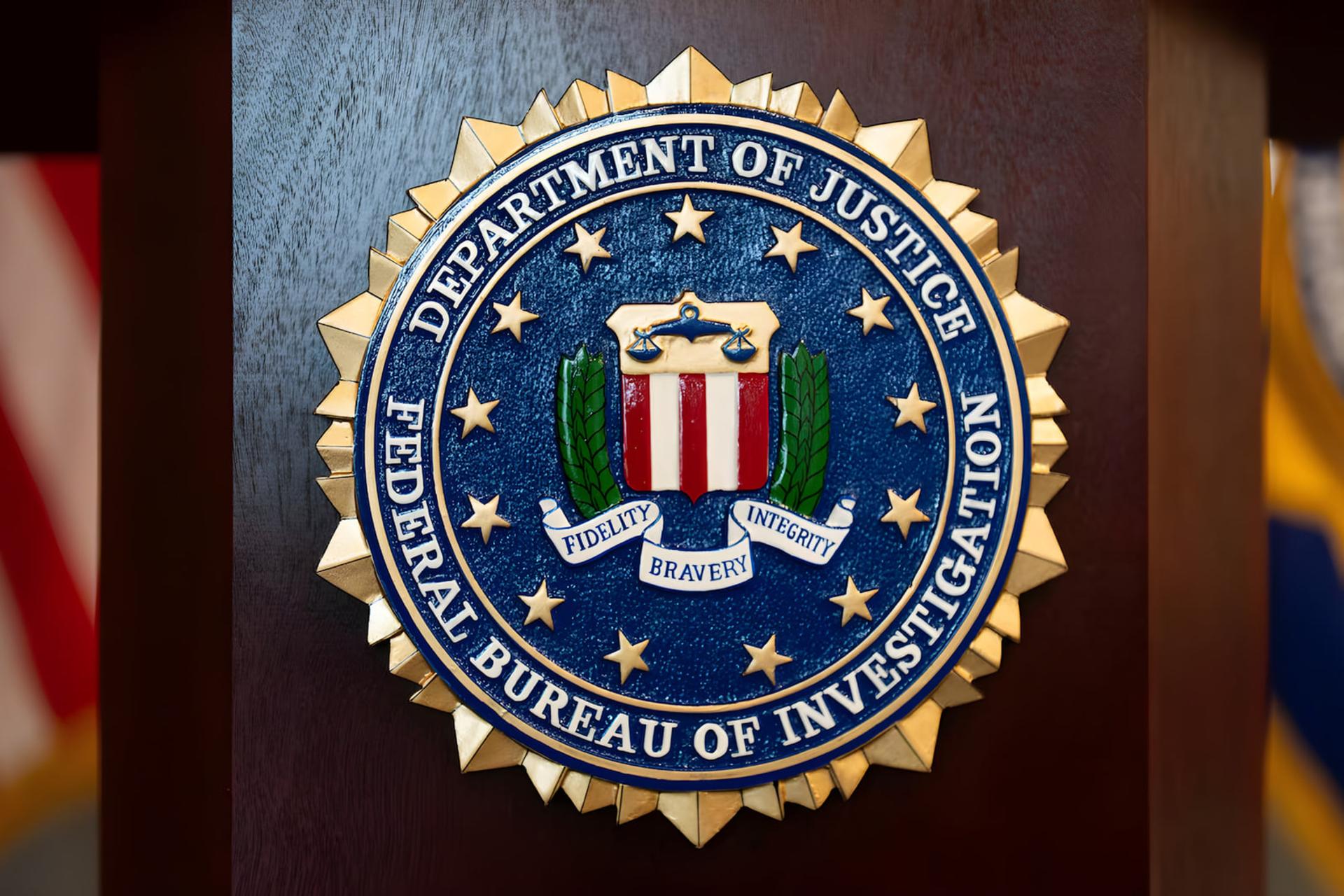 نشان طلایی و آبی سازمان تحقیقات فدرال (FBI) روی یک پایه چوبی