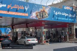 پمپ بنزین با تابلوی تبلیغاتی بزرگ در یک ایستگاه سوخت‌گیری