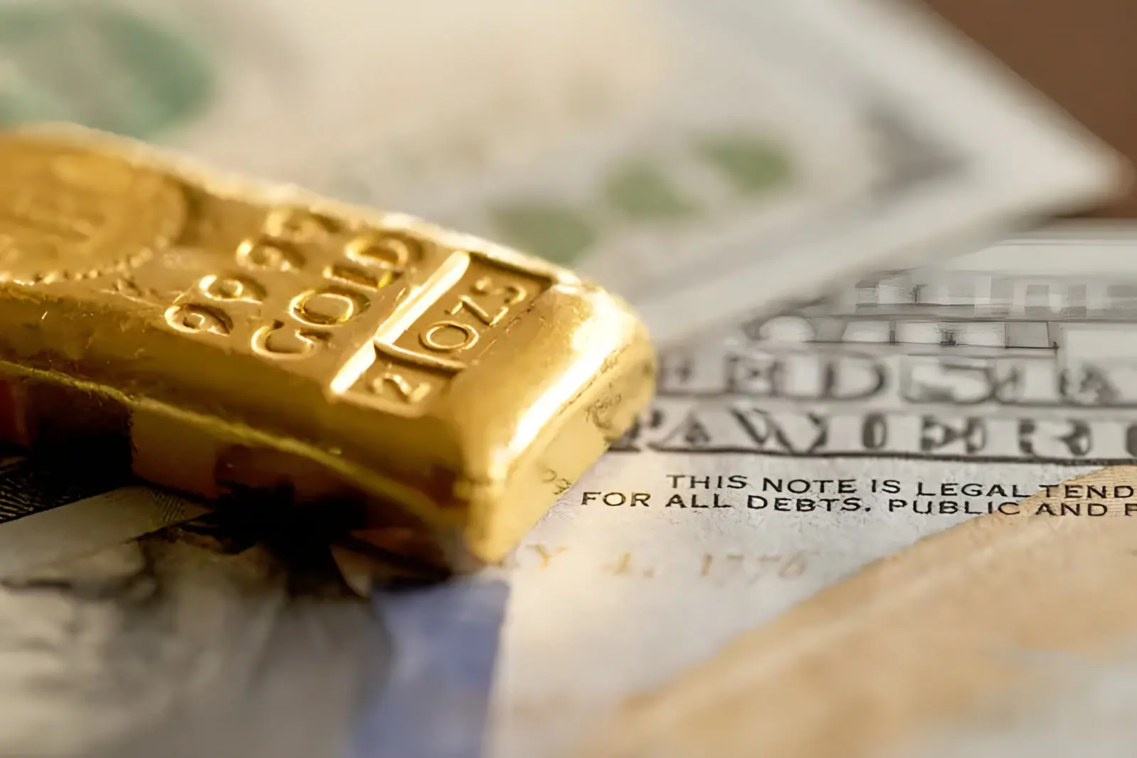 شمش طلا (Gold Bar) روی دسته‌ای از اسکناس‌های دلار آمریکا