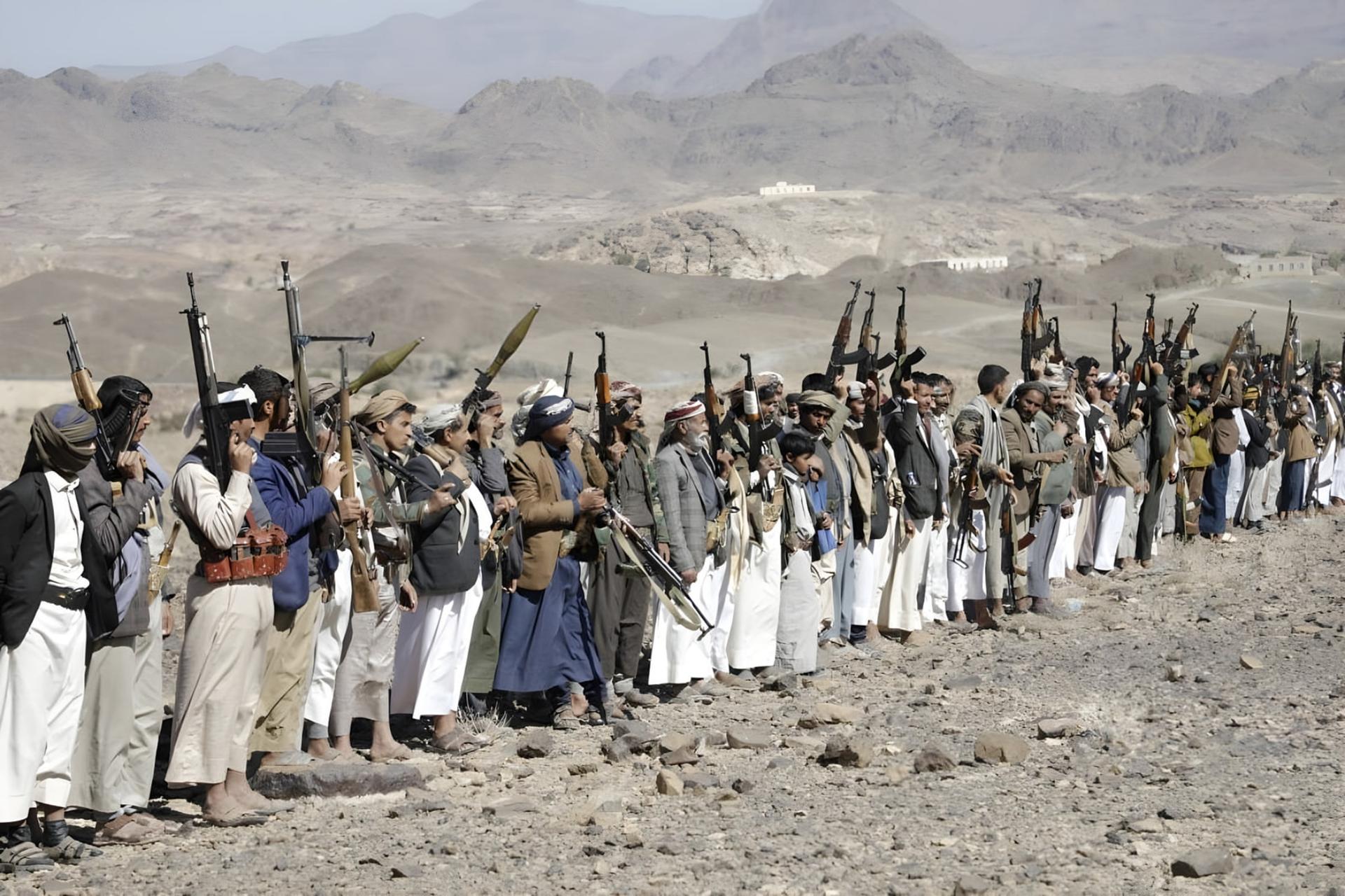 مجموعه‌ای از جنگجویان حوثی (Houthis) با سلاح‌های خودکار در یک منطقه کوهستانی و خشک