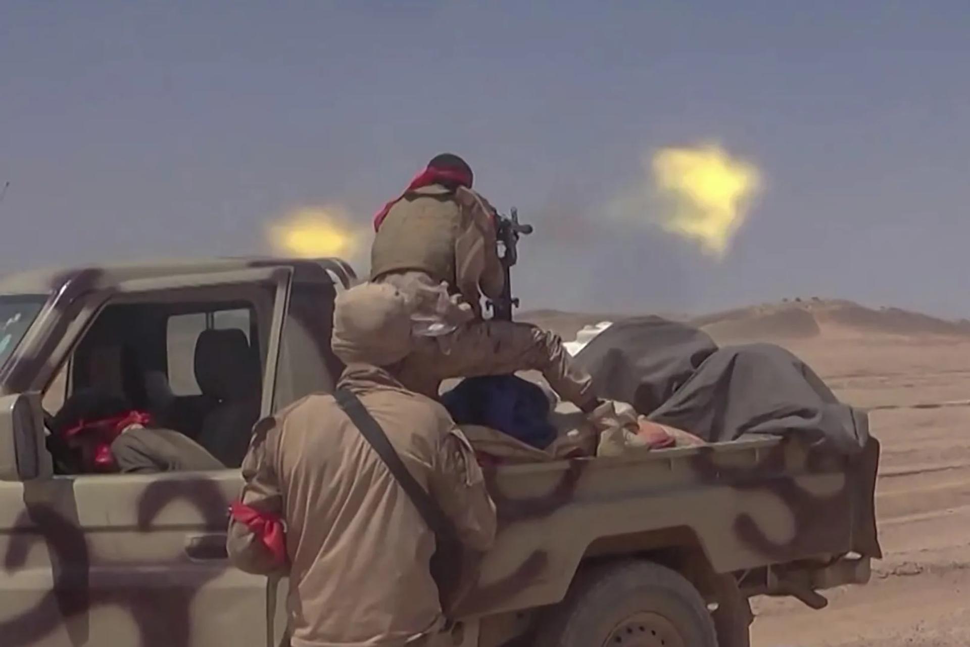 مبارزان حوثی (Houthis) در حال شلیک با تیربار نصب‌شده روی خودروی فنی در بیابان