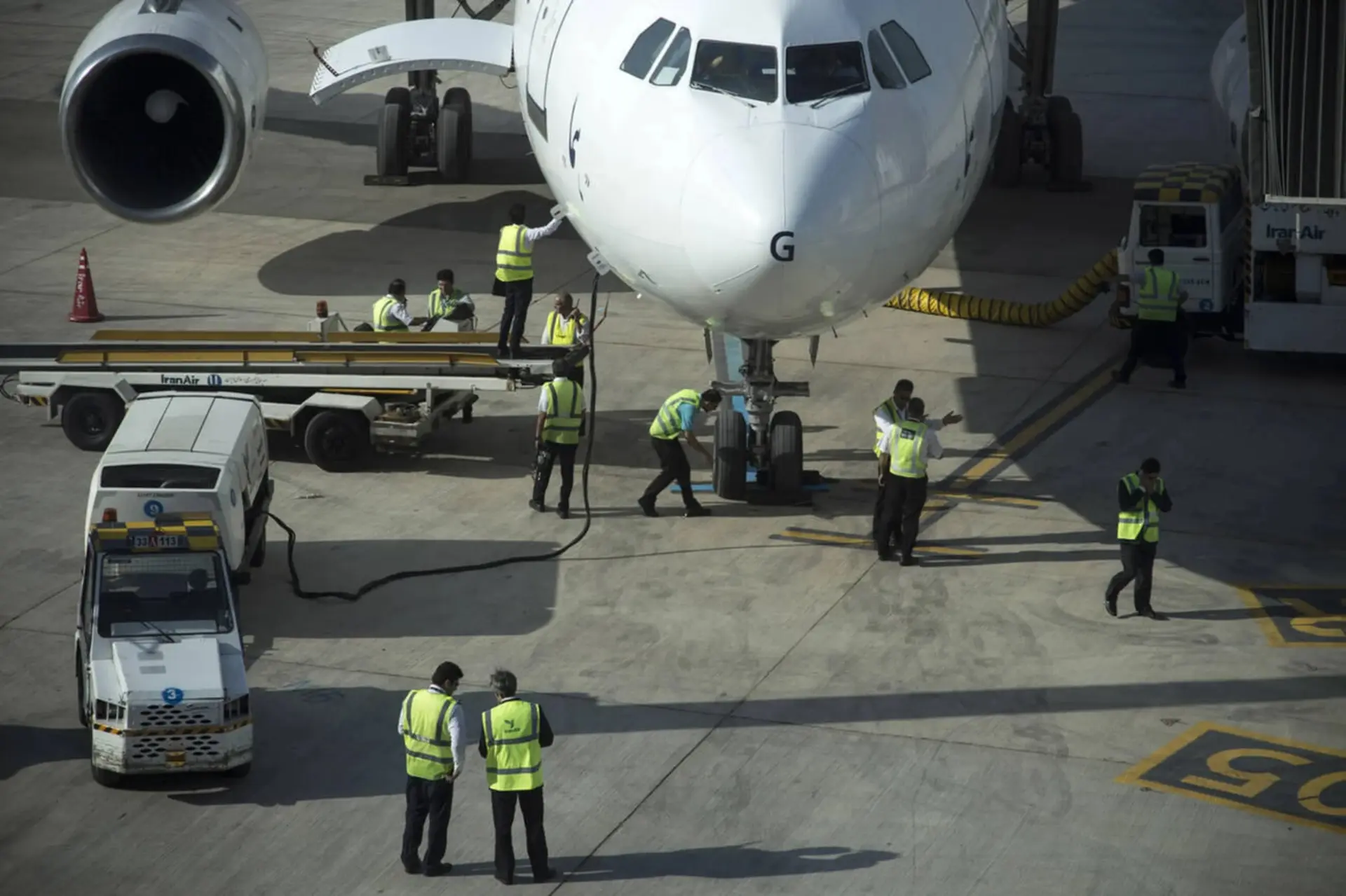 تیم فنی و پرسنل زمینی در حال بازبینی هواپیمای ایران‌ایر (Iran Air) در فرودگاه