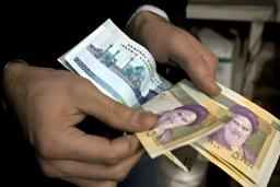 اسکناس‌های ریال ایران در دستان یک فرد برای پرداخت یا شمارش