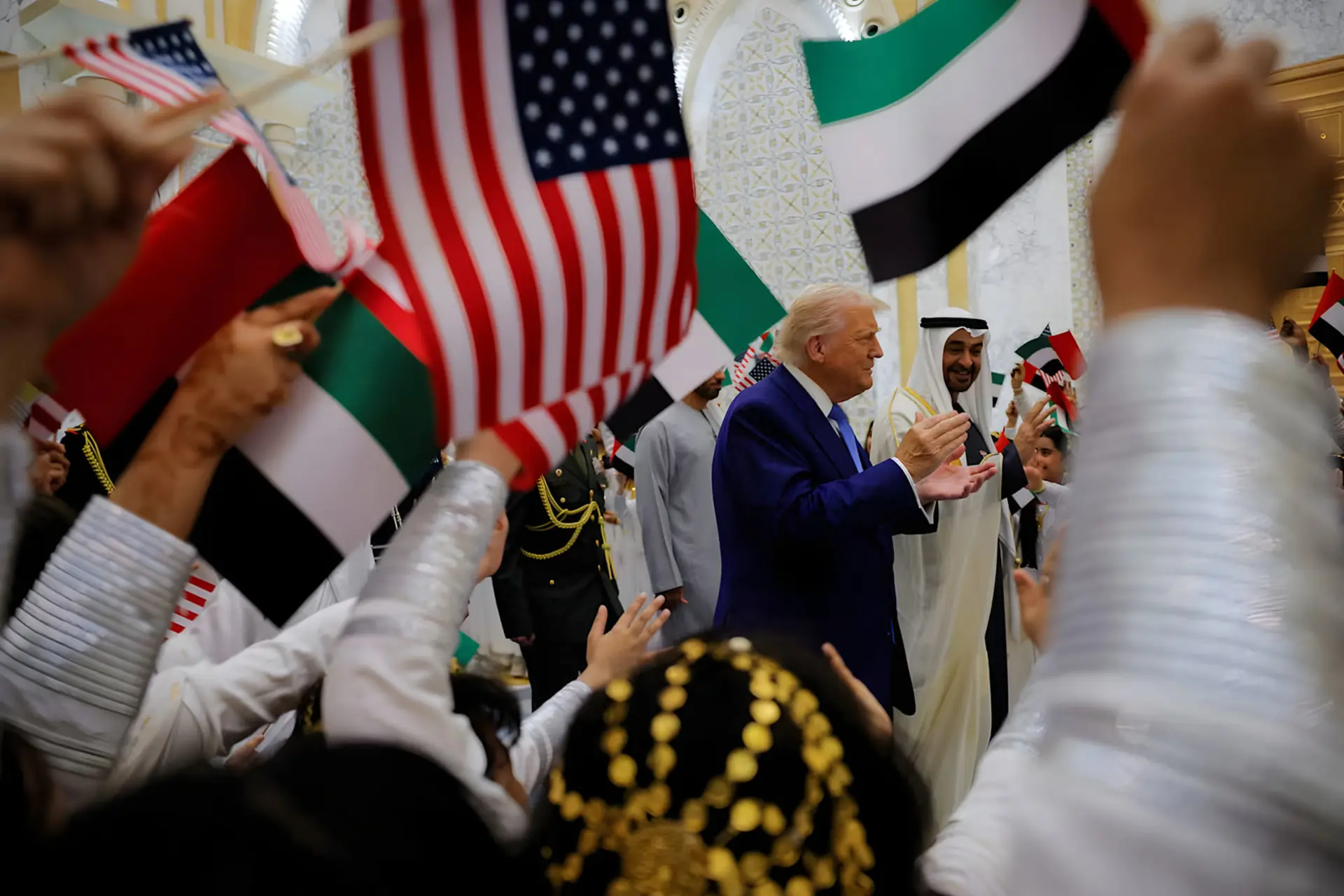 جو بایدن (Joe Biden) در میان پرچم‌های آمریکا و امارات متحده عربی