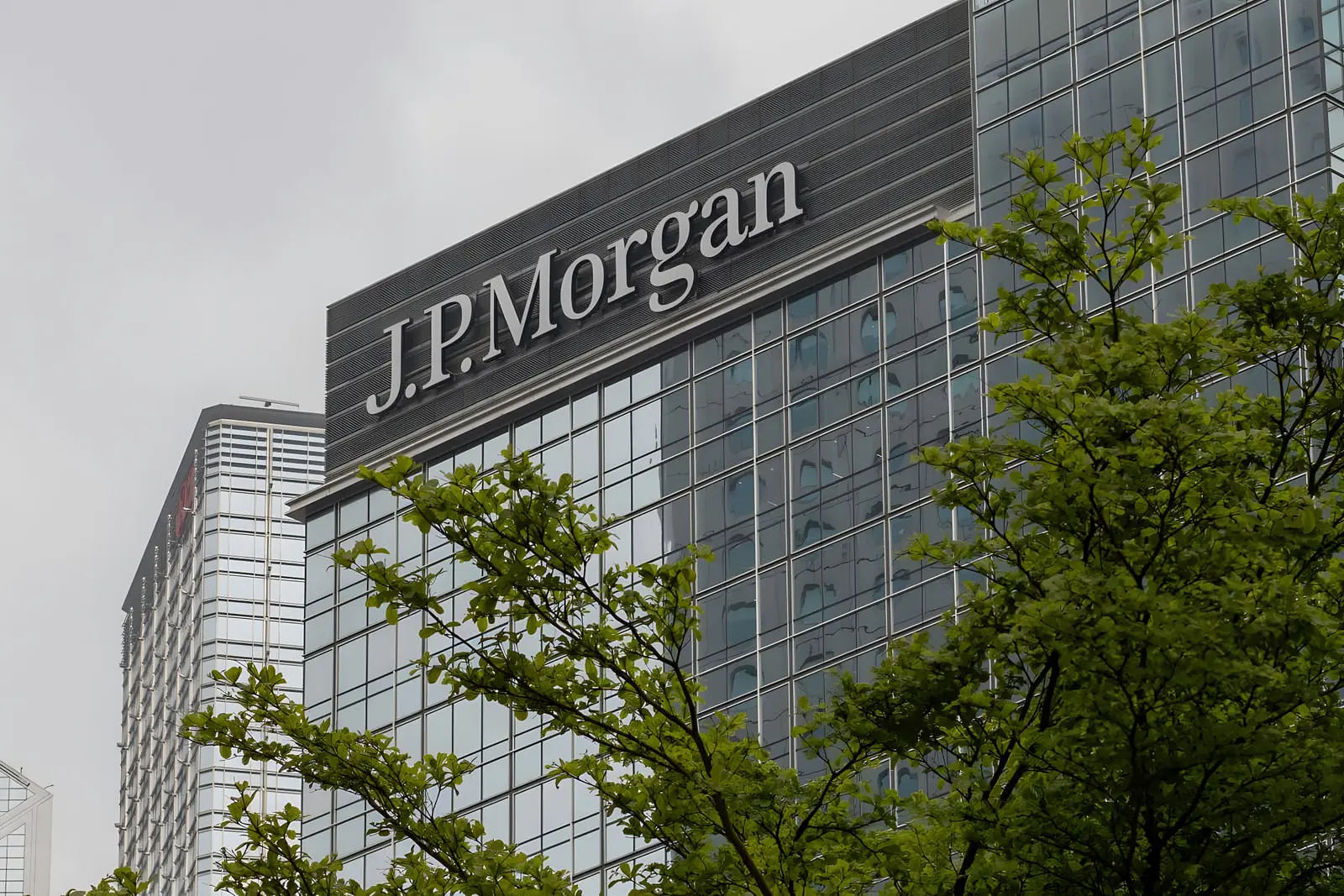 نمای ساختمان بانک جی‌پی مورگان (J.P. Morgan) با نمای شیشه‌ای و درختان سبز