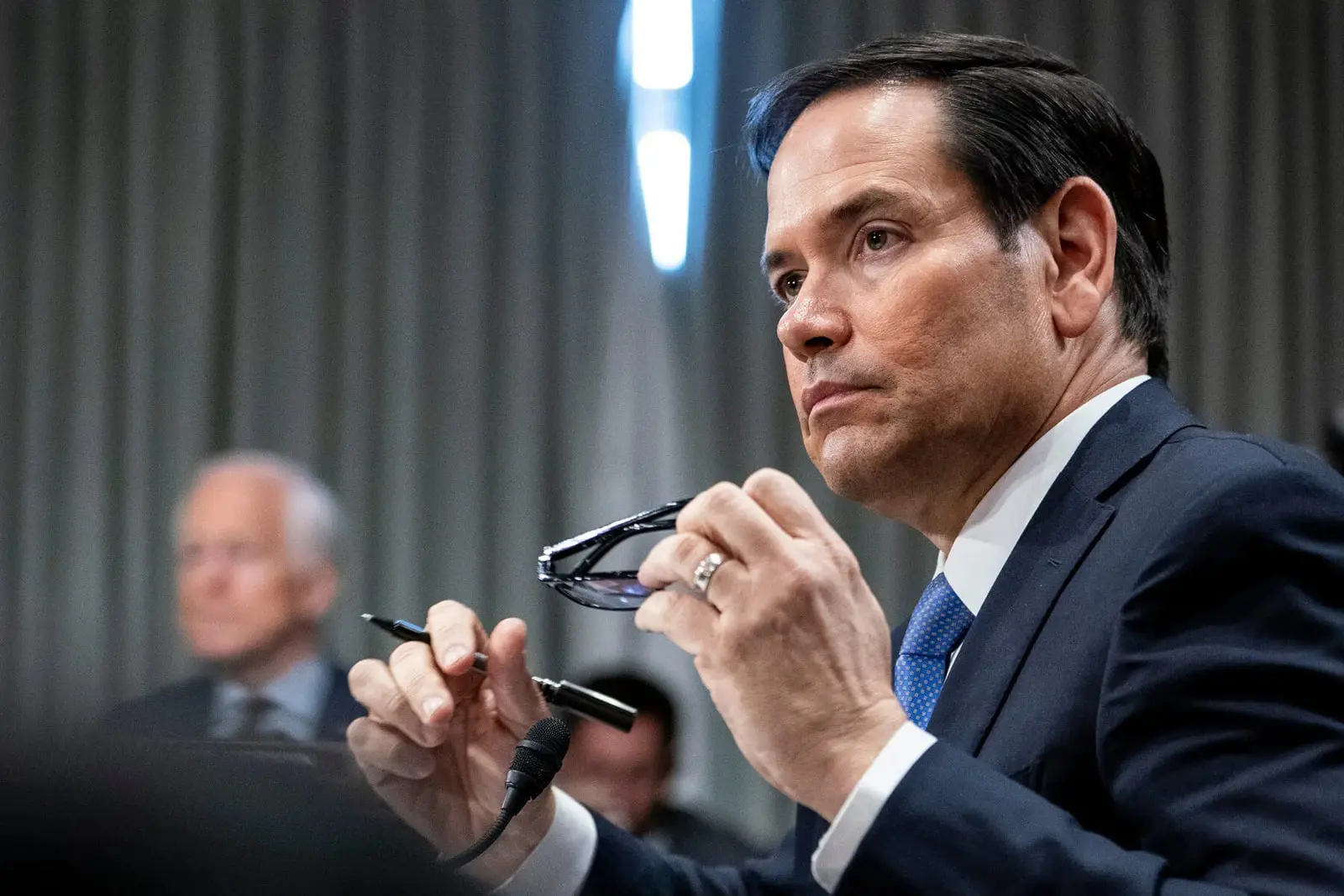 مارکو روبیو (Marco Rubio) در حالی که عینک خود را در دست دارد