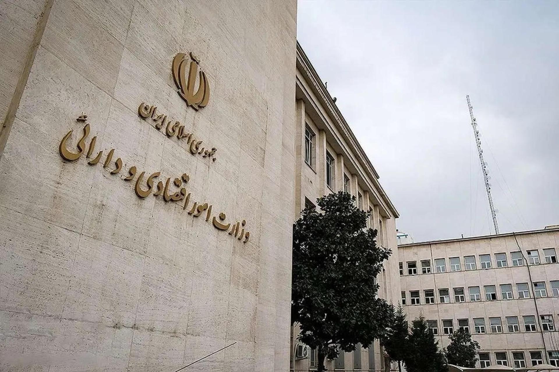 نمای نمای بیرونی ساختمان وزارت امور اقتصادی و دارایی ایران با نشان رسمی جمهوری اسلامی روی دیوار سنگی.