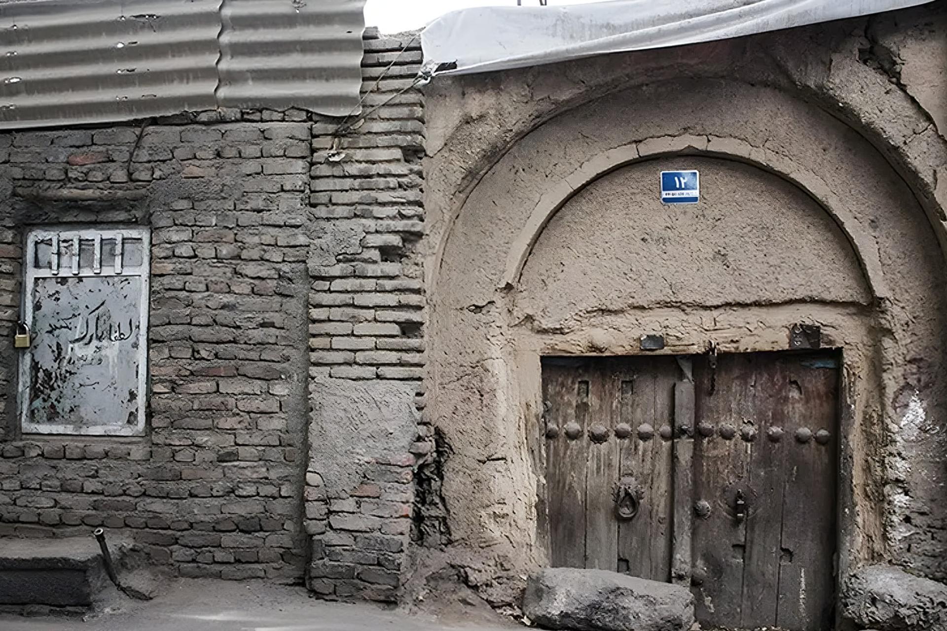 دیوار آجری و در چوبی قدیمی در یک ساختمان فرسوده