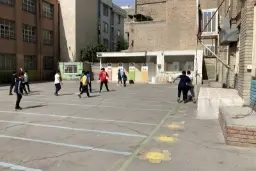 دانش‌آموزان در حیاط یک مدرسه خصوصی در حال بازی در فضای باز