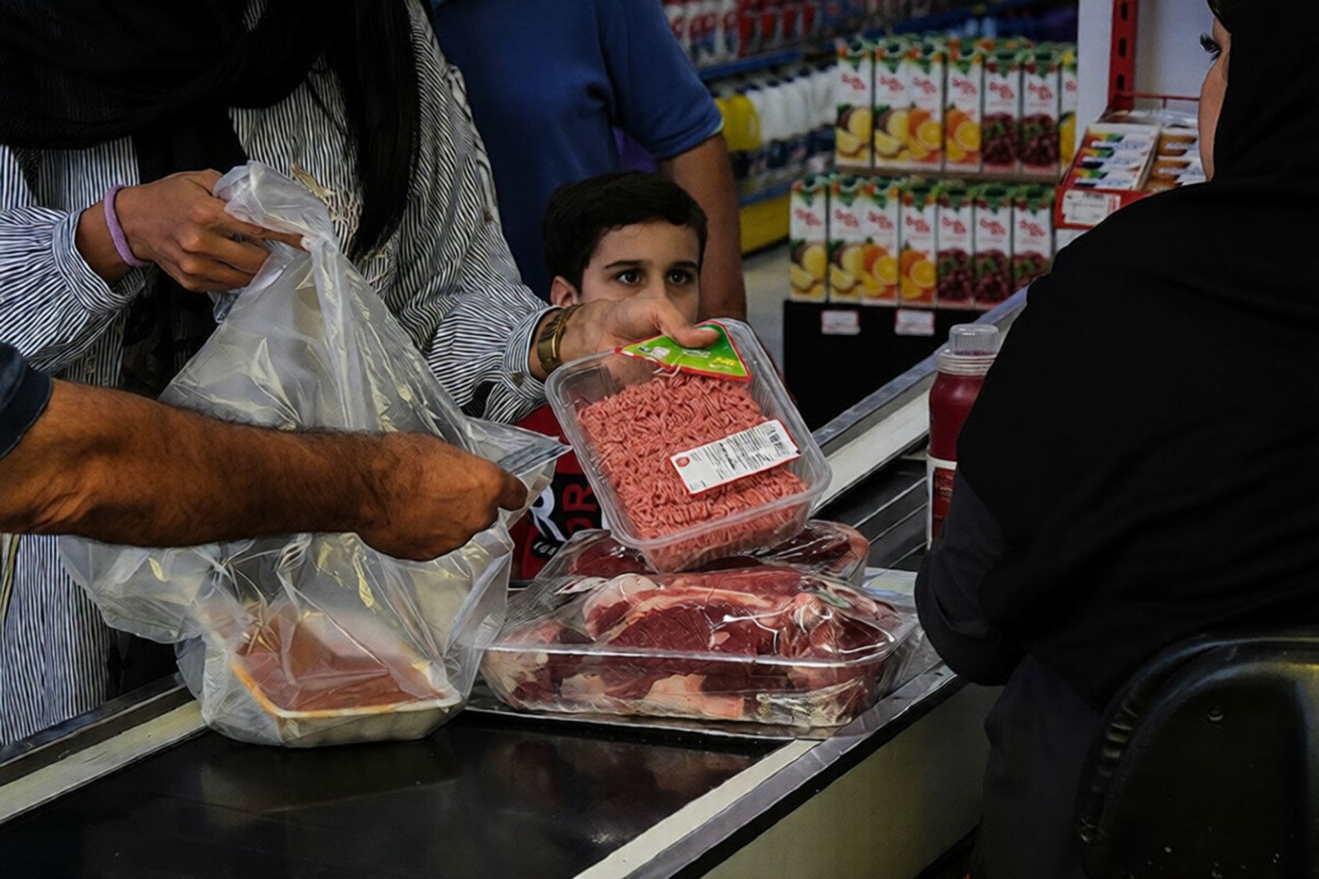 پسربچه ای همراه خانواده در حال خرید از فروشگاه