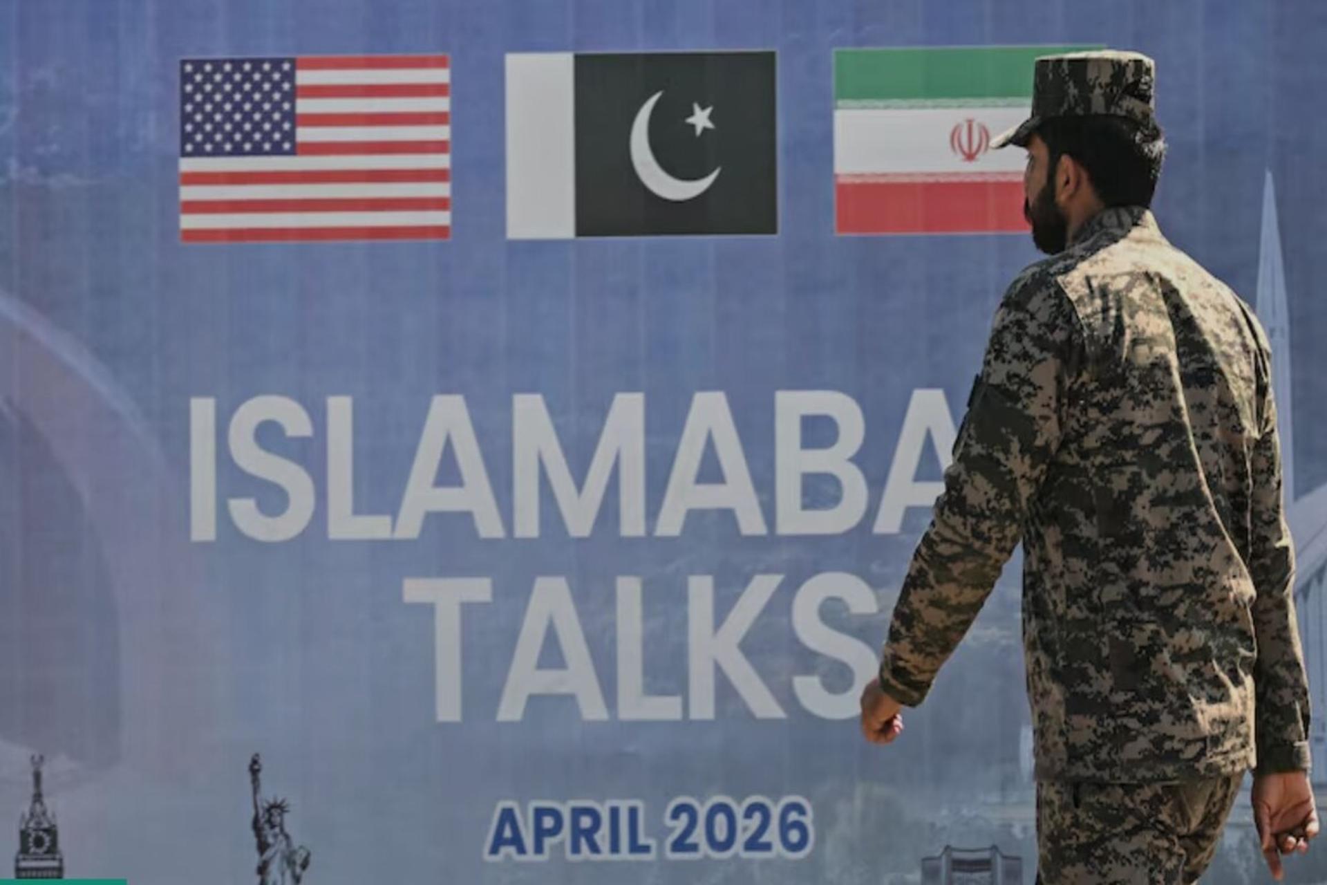 تصویر بنر مذاکرات اسلام آباد و یک نظامی که در حال دژبانی است