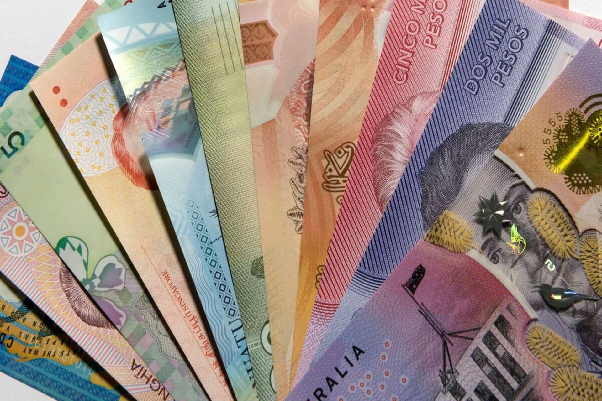 نمونه‌هایی از اسکناس‌های پلیمری کشورهای مختلف با طراحی‌های رنگی و پنجره‌های امنیتی شفاف