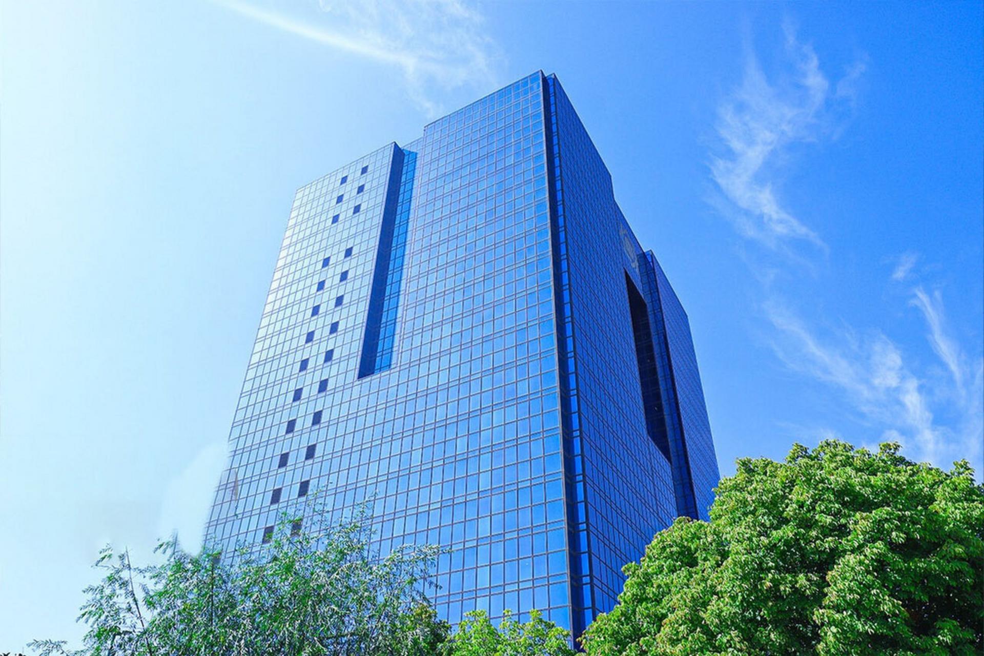 نمای بیرونی برج شیشه‌ای بانک مرکزی ایران با آسمان آبی در پس‌زمینه