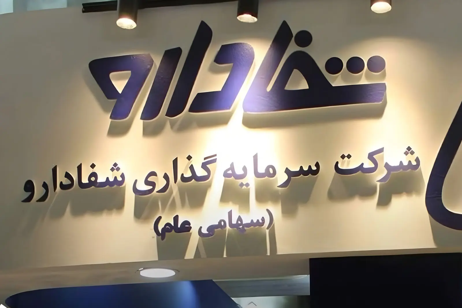 لوگوی برجسته شرکت سرمایه‌گذاری شفادارو روی دیوار سفید