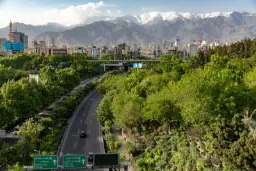 نمای شهر تهران (Tehran) با کوه‌های پوشیده از برف در پس‌زمینه